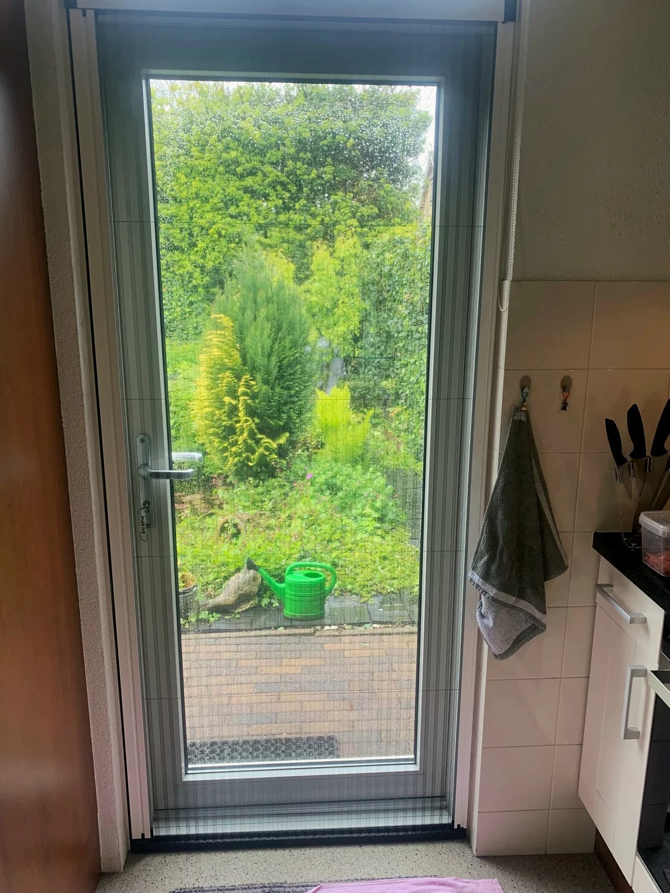 Gesloten plissehordeur met zicht op de tuin